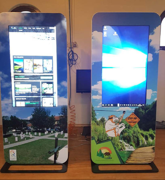 Two digital display stands with screens showing outdoor scenes and graphics.